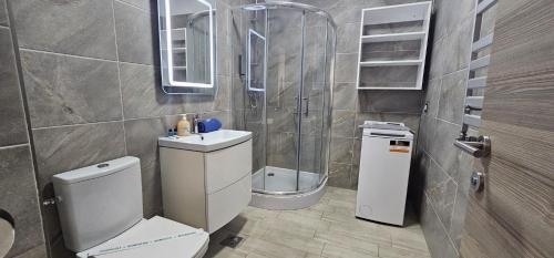 a bathroom with a toilet and a sink and a shower at Azizi Apartments Beach & Spa Resort piscina incalzita in Mamaia Nord