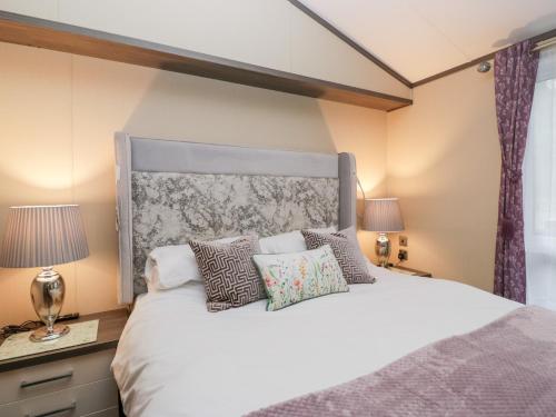 a bedroom with a large white bed with pillows at Feather Hill Lodge White Cross Bay, Skiptory Howe 38 in Windermere