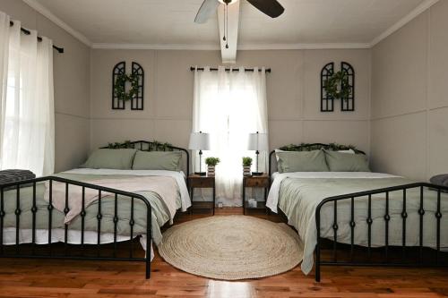 a bedroom with two beds and a ceiling fan at The Bulldog Farmhouse - 100 year old home in Athens