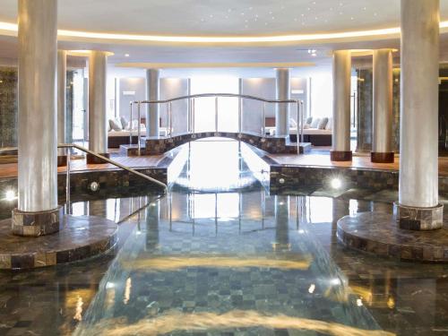 a lobby with a staircase in a building at Sofitel Montevideo Casino Carrasco & Spa in Montevideo