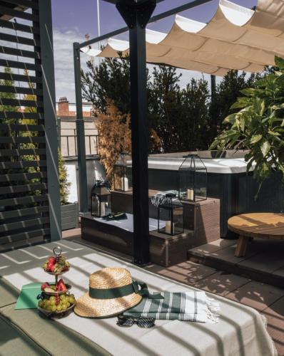 a hat and a plate of fruit on a patio at House of Hütter- Münchner Kindl, Small Luxury Hotels of the World in Munich