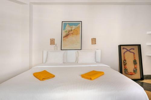 a white bed with two towels on top of it at Maison Alcazar in Tangier