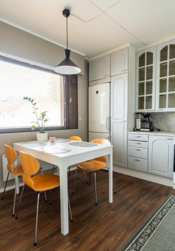 a kitchen with a white table and chairs at Cozy Ranua Koivutie townhouse with sauna & terrace in Ranua