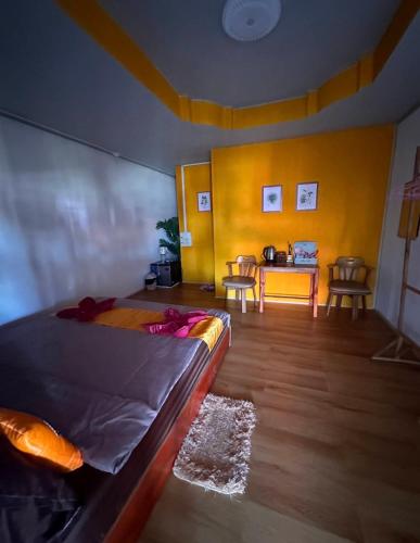 a bedroom with a bed and a table and chairs at Heaven Guesthouse in Pakse