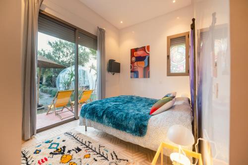 a bedroom with a bed with a blue blanket at Villa Roswell with Pool Privatisation in Heddad