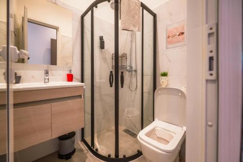 a bathroom with a shower and a toilet and a sink at Villa Roswell with Pool Privatisation in Heddad