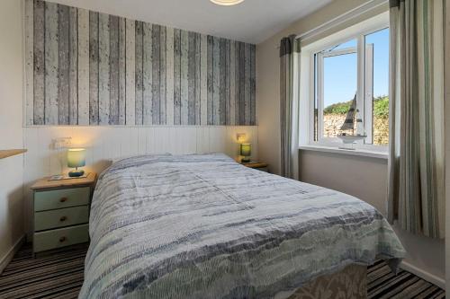 a bedroom with a large bed and a window at No 1 Cottage in Brixham