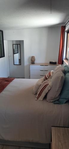 a bedroom with a large white bed with pillows at Chambres d'hôtes chez Mylène et Guillaume in Denezé-sous-Doué