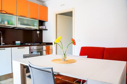 a kitchen with a white table with a vase of flowers on it at La casa di Leonardo in Civitanova Marche