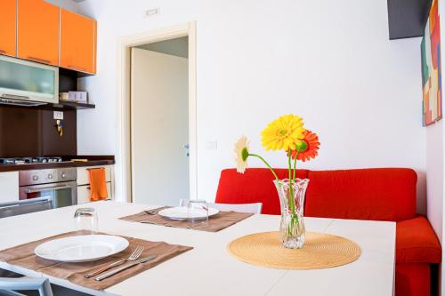 a kitchen with a table with a vase of flowers on it at La casa di Leonardo in Civitanova Marche