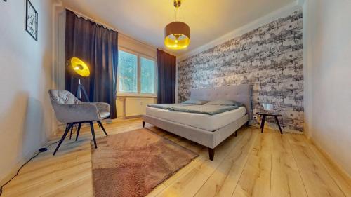 a bedroom with a bed and a chair at Senza apartman in Bratislava