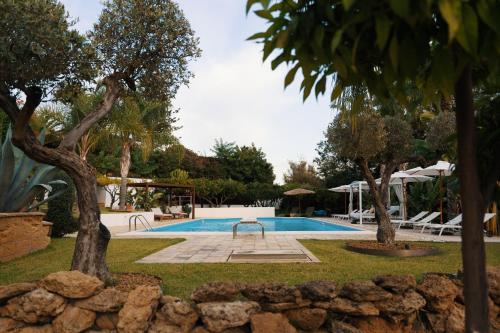 a swimming pool in a yard with trees at Emesh Boutique Suite in Agrigento