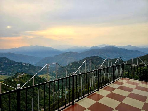 a balcony with a view of mountains in the distance at Hotel HiLL Mount View Dalhousie Chamba in Dalhousie