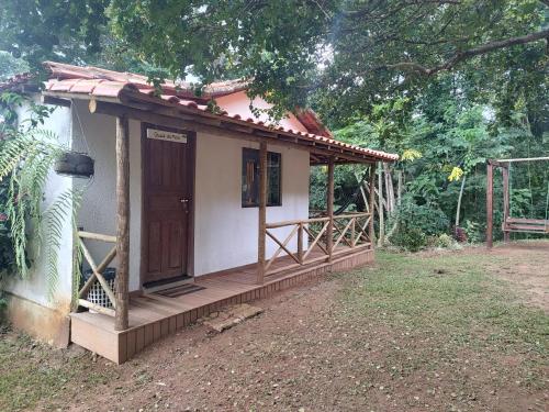 una pequeña casa con porche y puerta en Chalé da Mata Moeda, en Moeda
