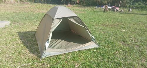 a green tent on the grass in a field at Mihunga Campsite and Community Center Ruboni in Rubona