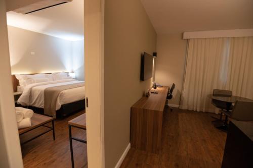a hotel room with a bed and a television at Intercity BH Expo in Belo Horizonte