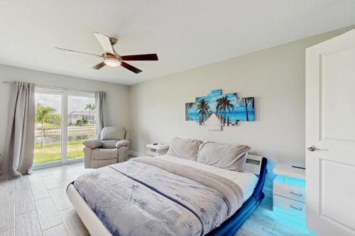 a bedroom with a bed and a ceiling fan at Into the Blue in Cape Coral Hospital Heliport