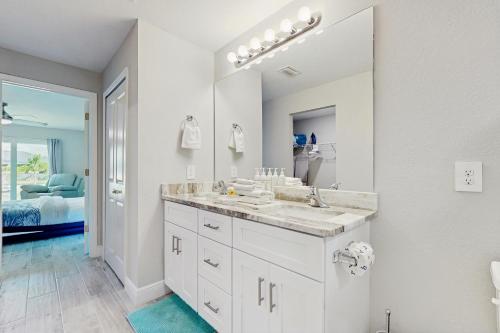 a white bathroom with a sink and a mirror at Into the Blue in Cape Coral Hospital Heliport