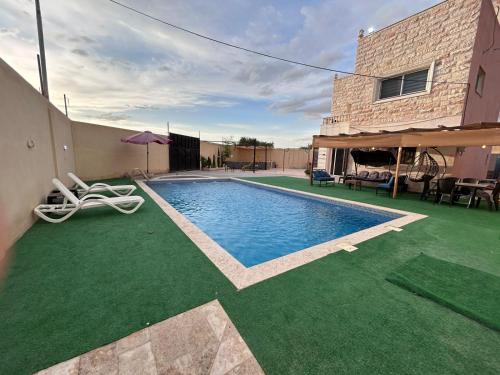 Casa con piscina con césped en Nay's Chalet, en Shūnat Nimrīn