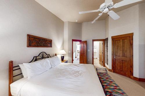Un dormitorio con una cama blanca y un ventilador de techo. en The Trails at Storm Meadows - Val Gardena 2, en Steamboat Springs