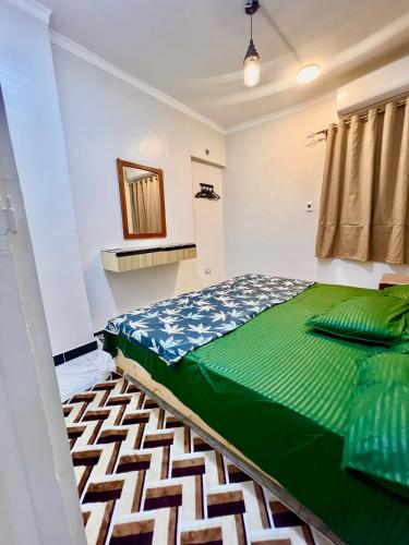 a bedroom with a green bed and a mirror at Super Elite apartment - Aswan city center apartments in Aswan