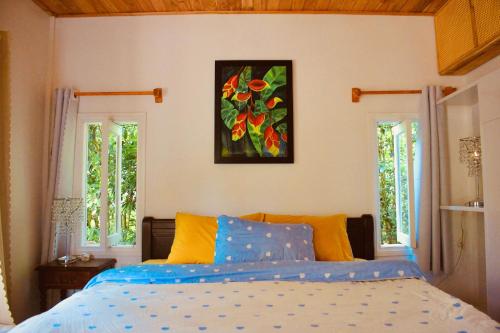 a bedroom with a bed and two windows at Spacious view house 2BR in Thôn Châu Chữ
