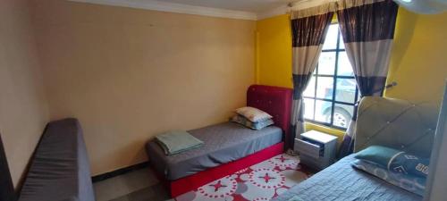 a small room with a bed and a window at Homestay Hajah Jamilah Sungai Tiram 04 in Ulu Tiram