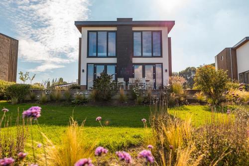 a house with a garden in front of it at Pavilion Villa Waterzicht | 10 Personen in Kerkdriel
