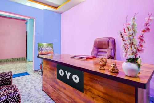an office with a desk with a chair and a vase of flowers at Hotel O Gurukrupa in Urāli