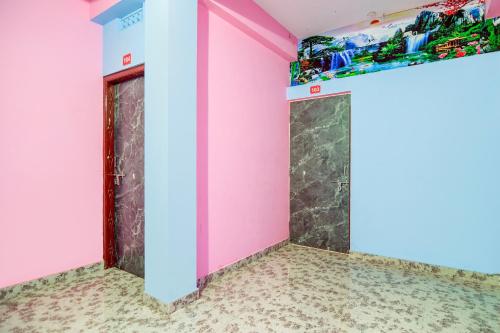 a room with pink walls and a shelf at Hotel O Gurukrupa in Urāli
