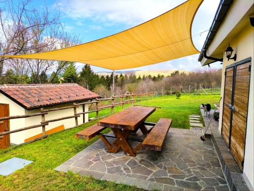 a picnic table with a yellow canopy on a patio at Casa vacanza Campotosto in Campotosto