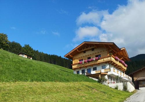 a building on a hill with flowers on it at Ferienwohnung Gipfelblick in Weerberg