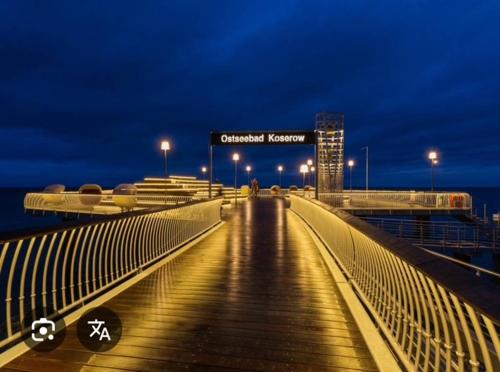 a bridge over the water at night with lights at Haus am Meer in Koserow in Ostseebad Koserow