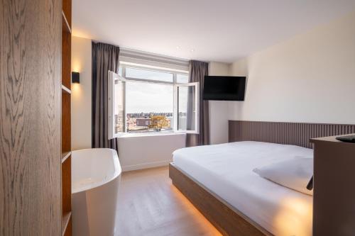 a bedroom with a bed and a large window at Four Stories in Scheveningen