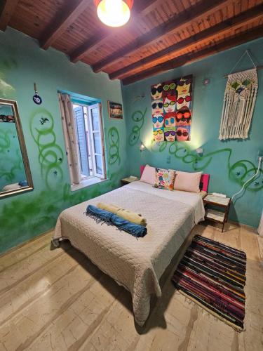 a bedroom with a bed in a room with green walls at LaLaLand in Mikonos