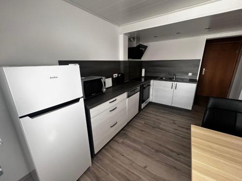 a kitchen with white appliances and a refrigerator at Fewo am Stadtrand von Bad Hersfeld in Bad Hersfeld