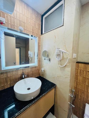 a bathroom with a sink and a mirror at Trimrooms Shubharambh Ayodhya in Ayodhya