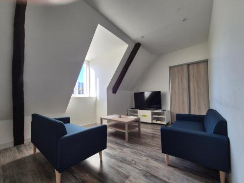a living room with two blue chairs and a tv at Grand appartement vue montagne in Ayzac-Ost