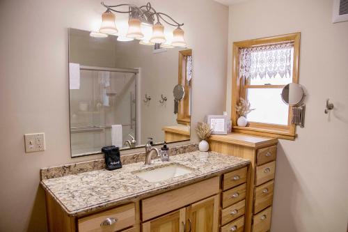 a bathroom with a sink and a large mirror at The Lodge on Lamoka in Bradford