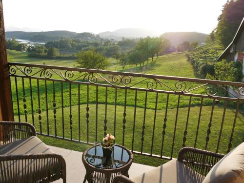 a balcony with a table with a view of a field at Hidden View House 