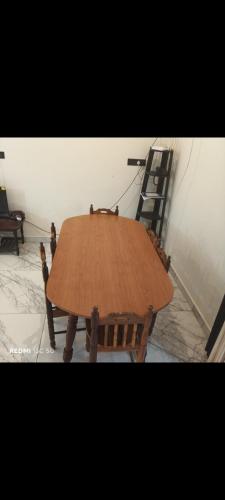 a wooden table in a room with a ladder at Nagesh paikera biligeri in Madikeri