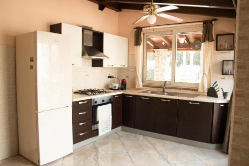 Una cocina con un refrigerador blanco y un fregadero. en Villa Forzisi locazioni brevi, en Fiumefreddo di Sicilia
