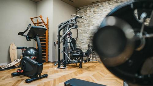 a gym with tread machines and a brick wall at AVO 2 room wellness apartment in Laax