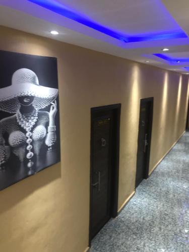a hallway with a picture of a woman wearing a hat at Skyflix Hotel & Suites in Agbara