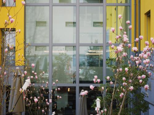 a window with pink flowers in front of a building at 21 House of Stories Città Studi in Milan