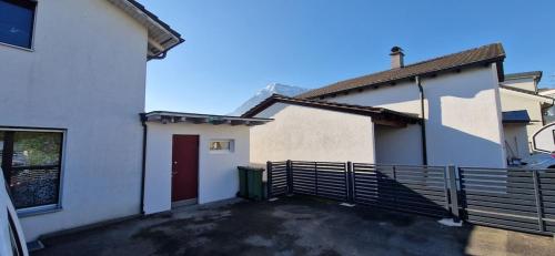 a white house with a red door and a fence at Smartes Business Studio in Immensee