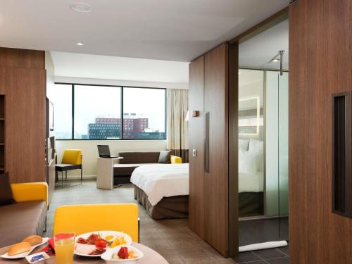 a hotel room with a bed and a table with food at Novotel Sofia in Sofia