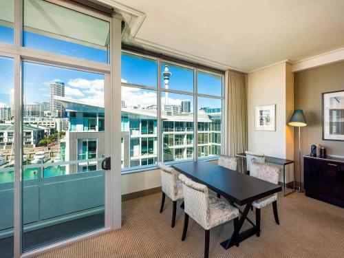 a room with a table and chairs and a large window at Sofitel Auckland Viaduct Harbour in Auckland