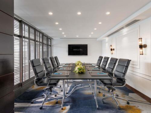 a conference room with a long table and chairs at Sofitel Auckland Viaduct Harbour in Auckland