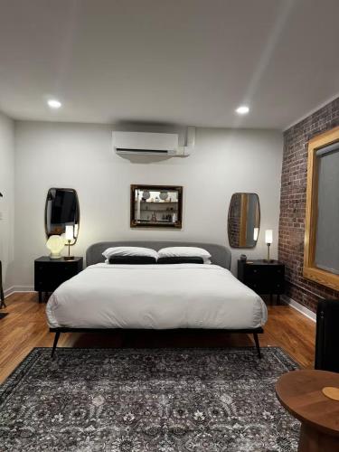 a bedroom with a white bed and a brick wall at Historic Downtown Studio, Steps to Bathhouse Row, Room # 203 in Hot Springs
